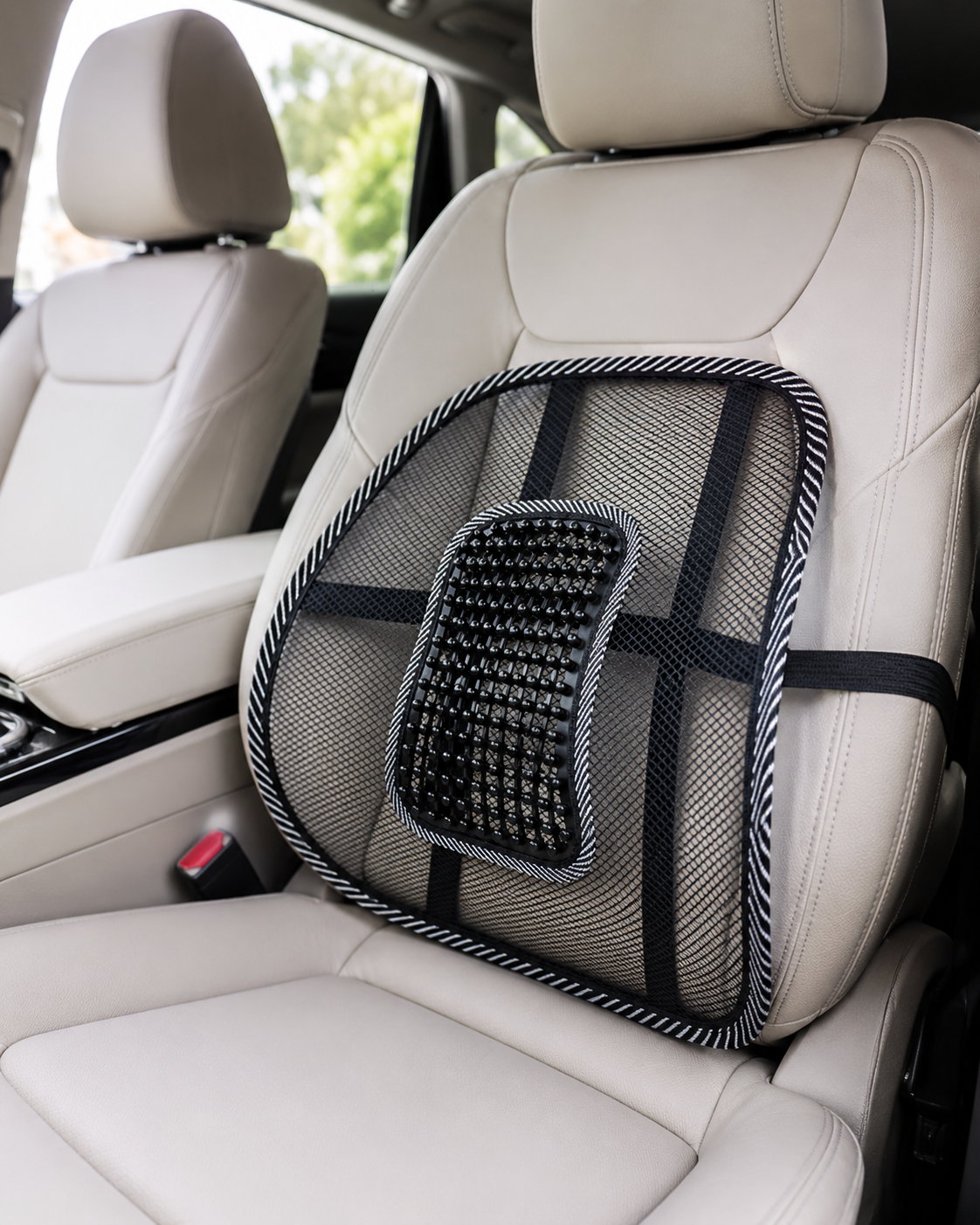 Support lombaire en résille noire avec perles de massage, installé sur un siège de voiture